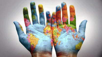 zwei Hände mit aufgemalter Weltkarte