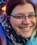 eine verschmitzt drein blickende und in einen Schal geh&uuml;llte Frau